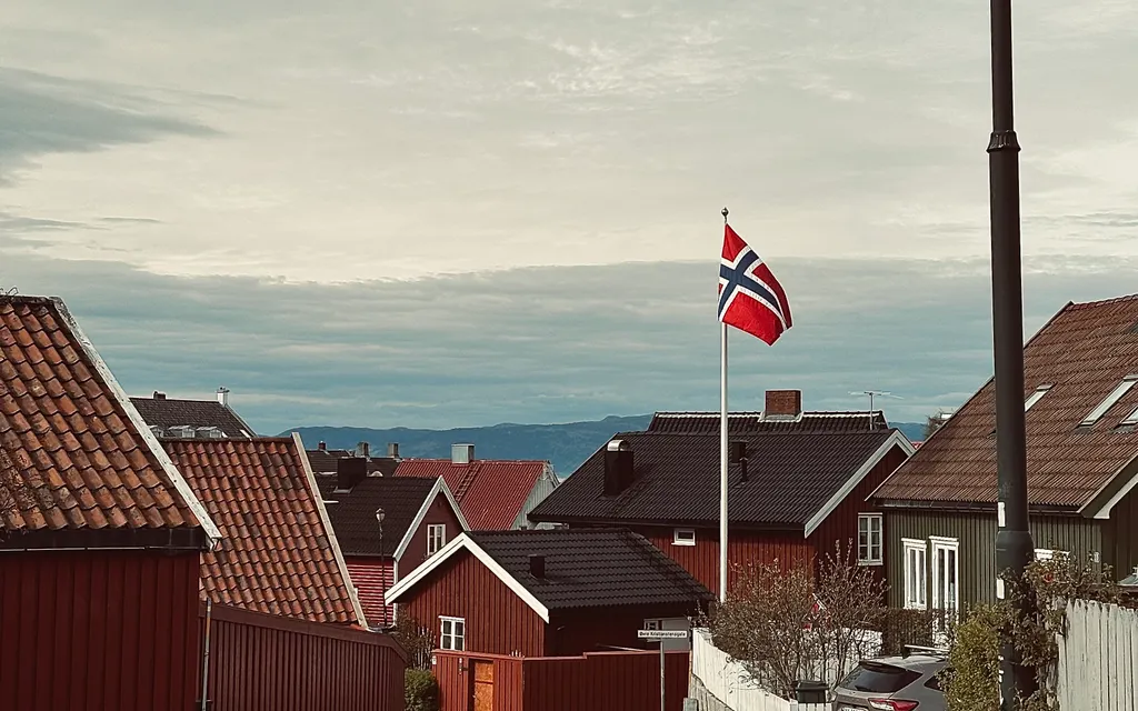 Utsikt over en norsk bygd med trehus og fjell i bakgrunnen